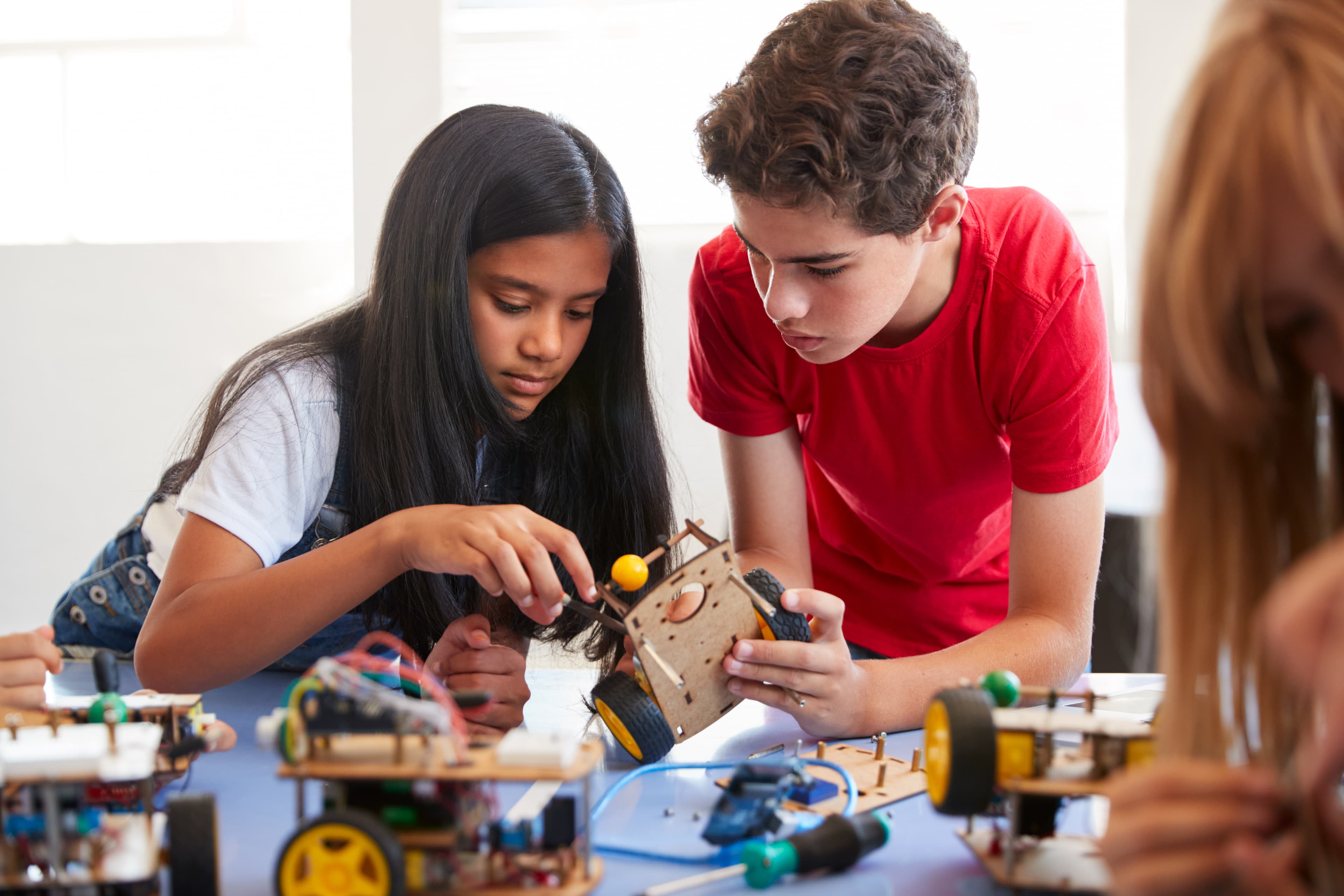 Students building a robotics project together